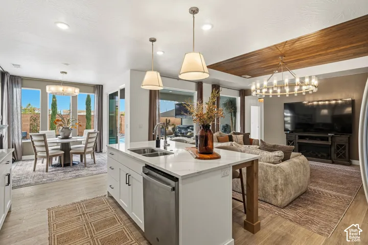 Open-concept living space with wood-finish flooring, a kitchen island with stone countertops, stainless steel appliances, and a wood panel ceiling accent