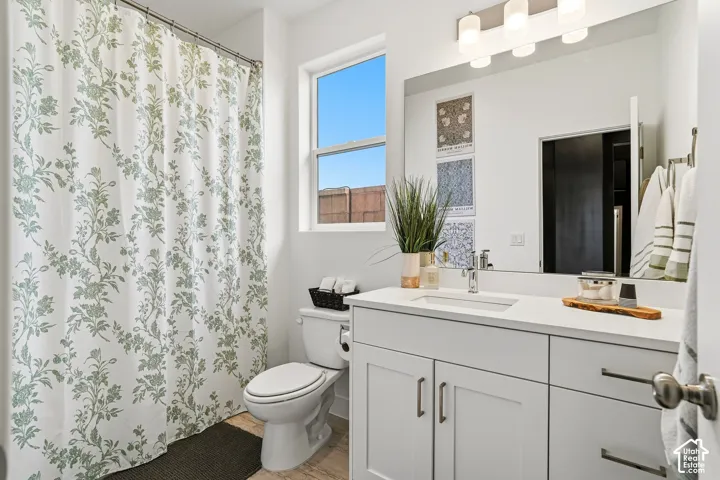 White vanity with integrated sink and chrome faucet, under-cabinet storage, and an expansive mirror