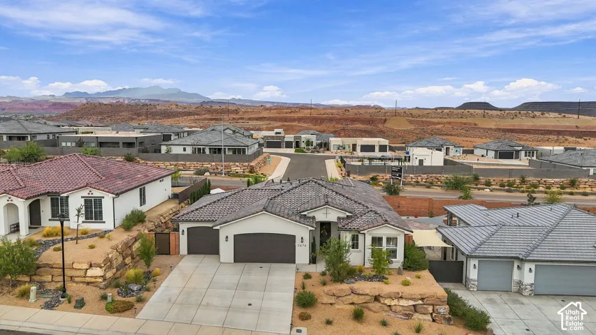 Single-story residence featuring a tile roof, an integrated two-car garage, and desert landscaping