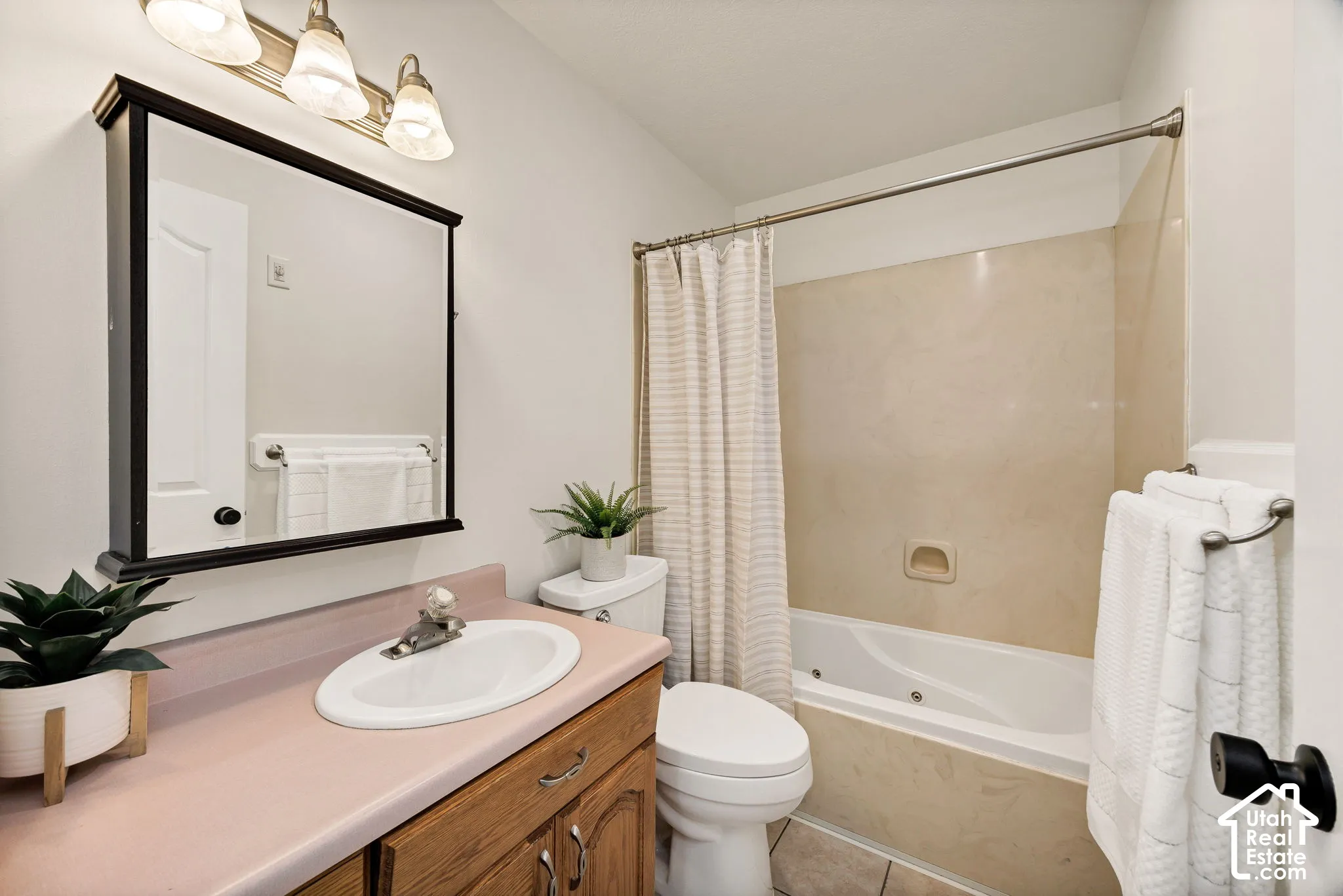 Vanity with a built-in sink, wood-finish cabinetry, and a framed mirror
