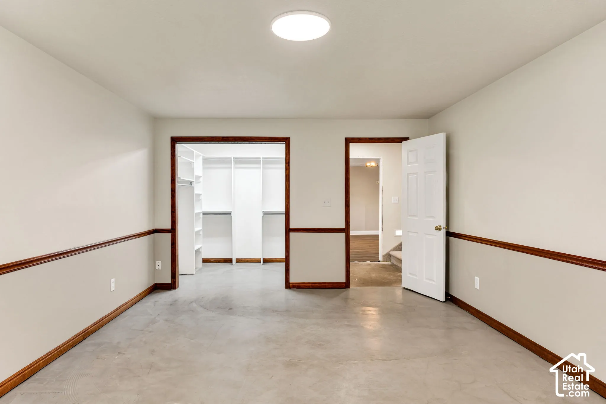 Spacious bedroom with concrete flooring.
