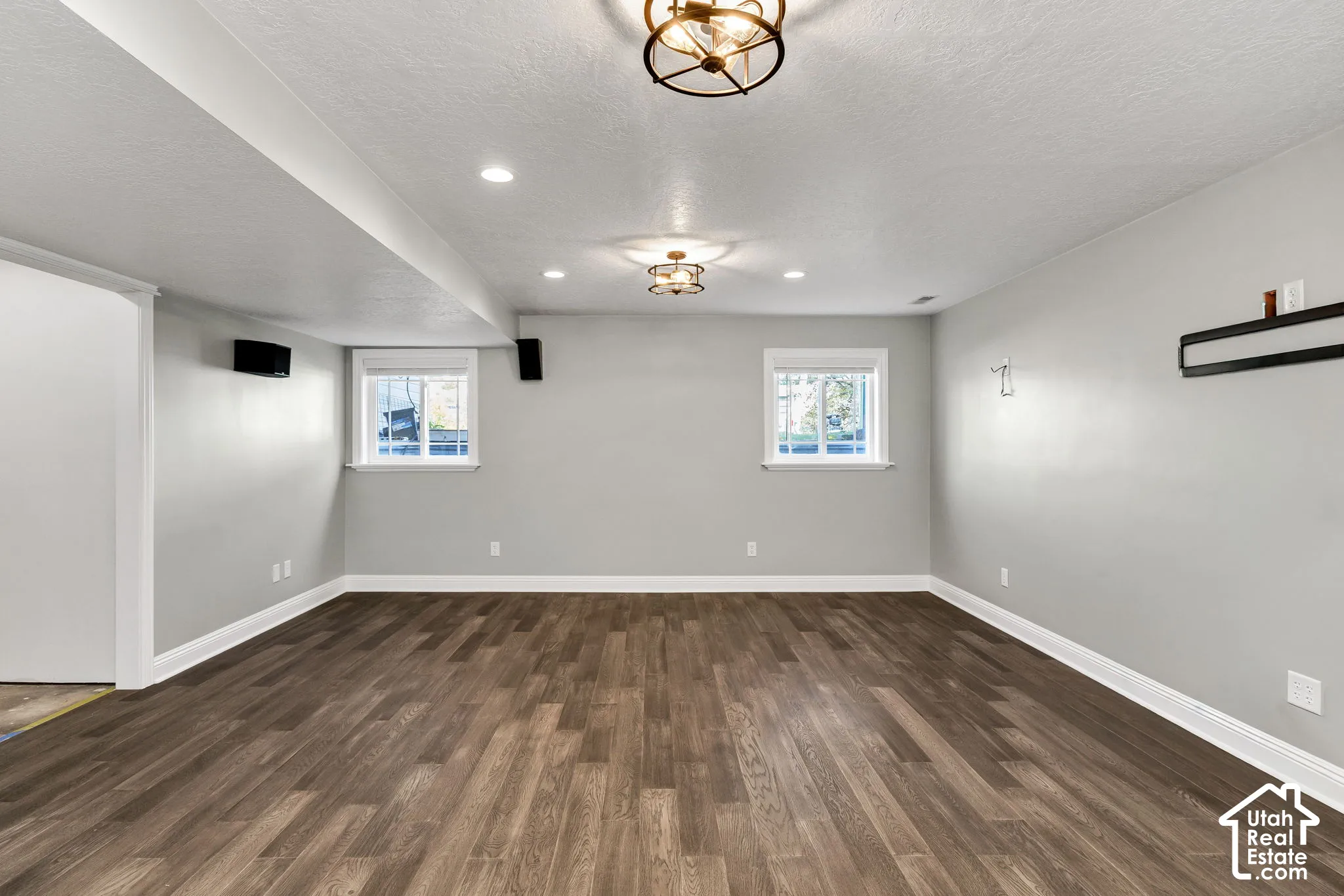 Wood-finish flooring, recessed lighting, two windows, and two ceiling-mounted light fixtures
