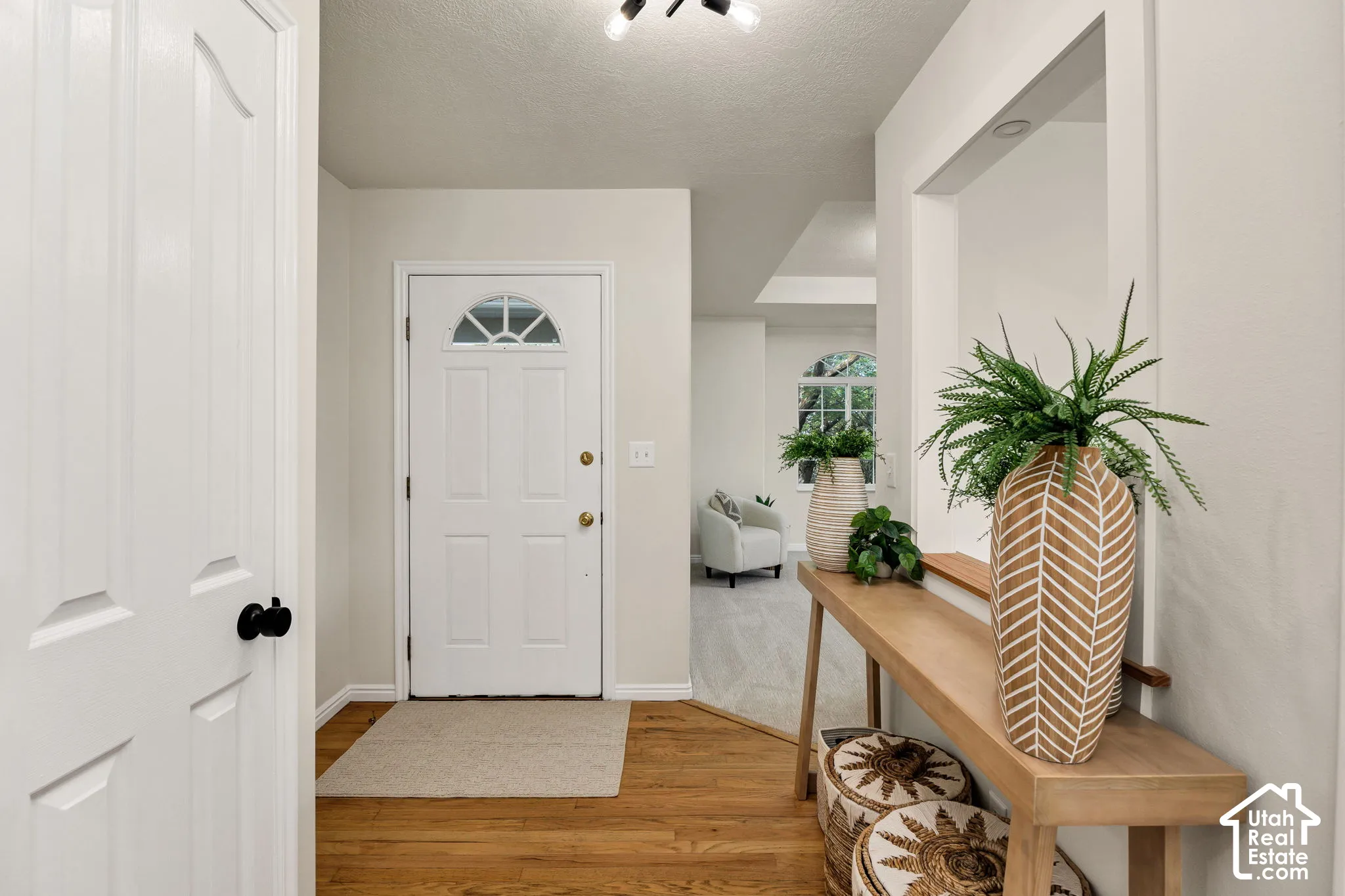 Entryway with wood-finish flooring, a white paneled door with a half-round window, and recessed lighting