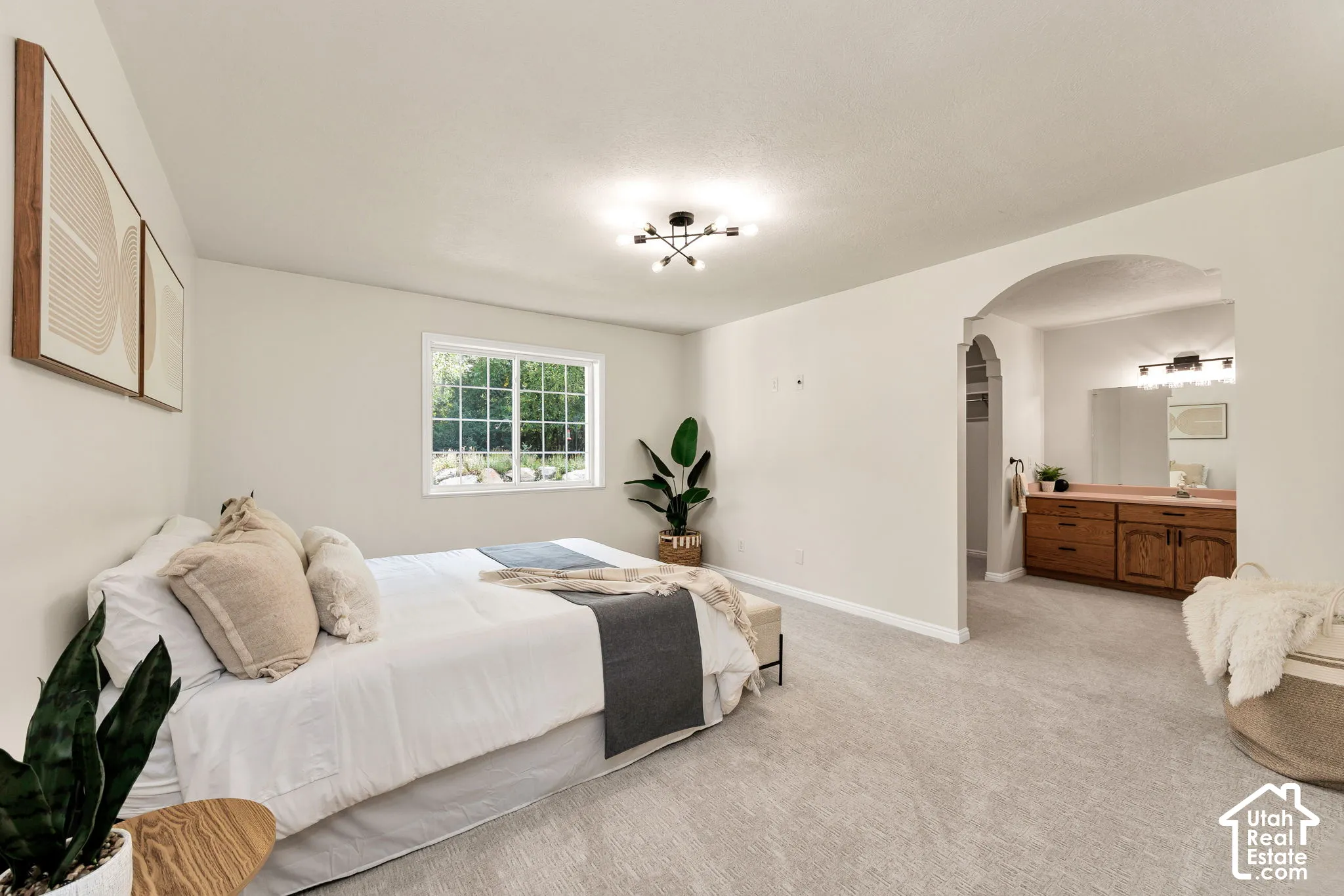 Recessed window with white framing, light neutral wall color, contemporary ceiling light fixture, arched doorway, and light-colored carpeting