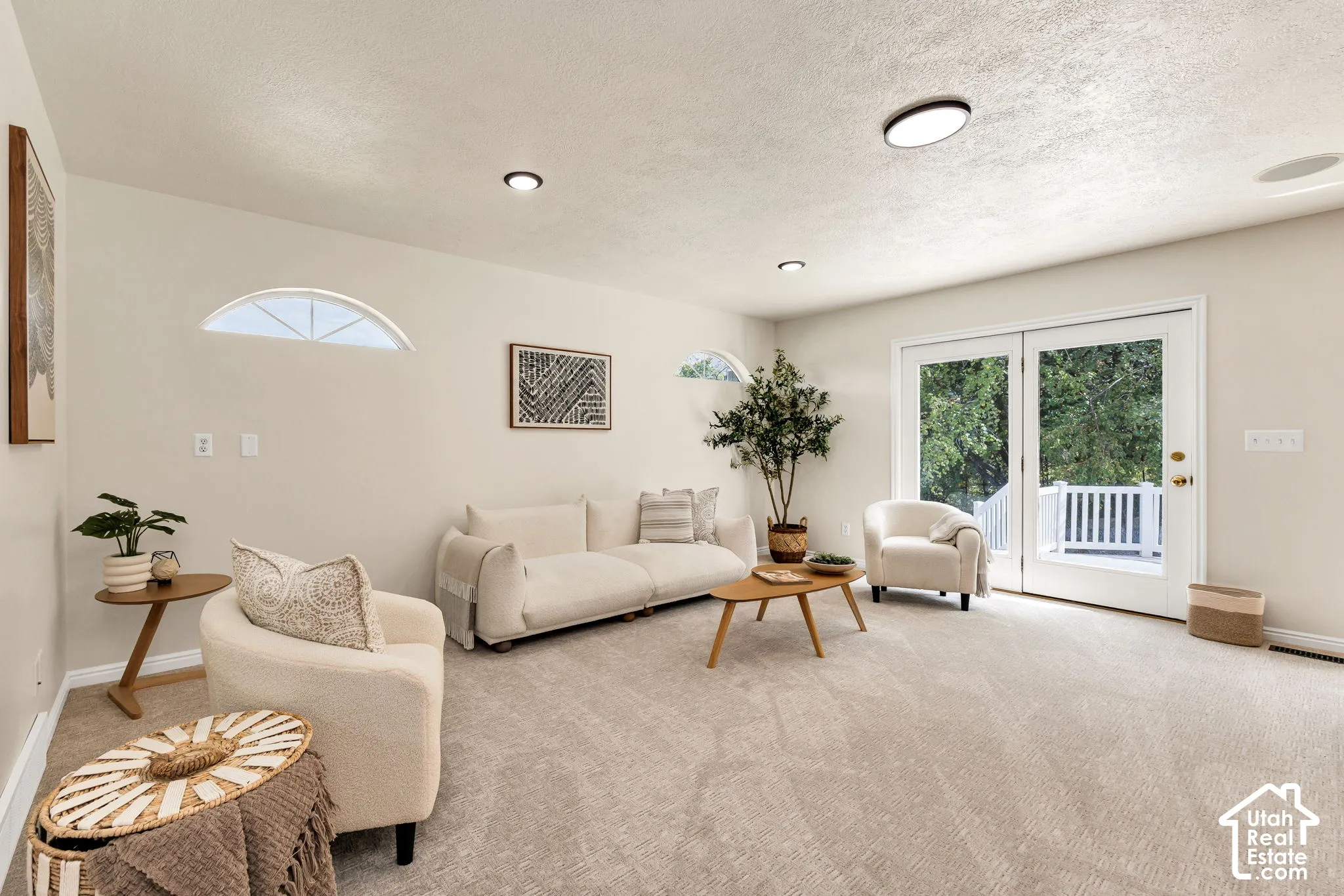 Plush carpet flooring, recessed ceiling lighting, arched transom window, and double French doors opening to an exterior deck