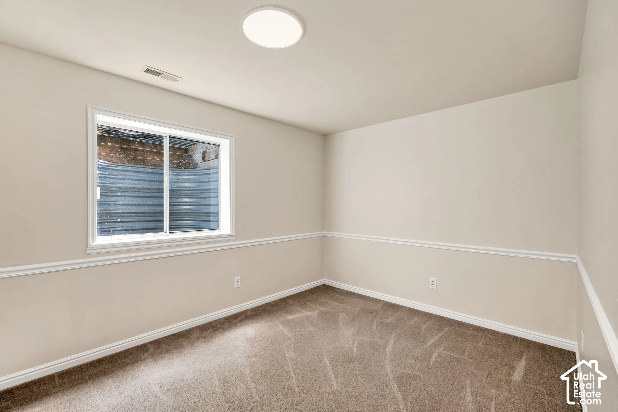 Recessed window with white trim, neutral carpet, and white wall molding