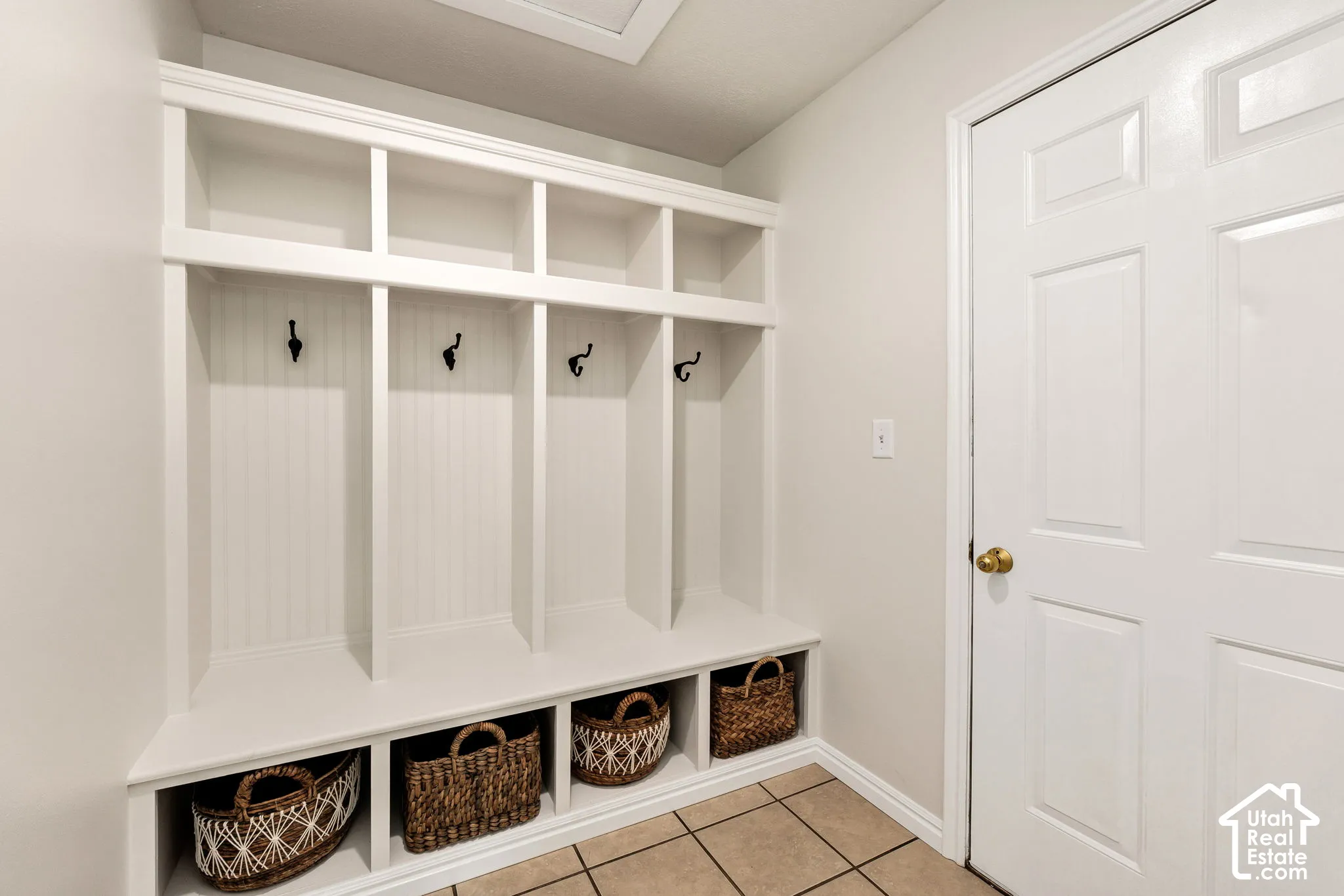 Built-in white storage unit with multiple cubbies and bench seating