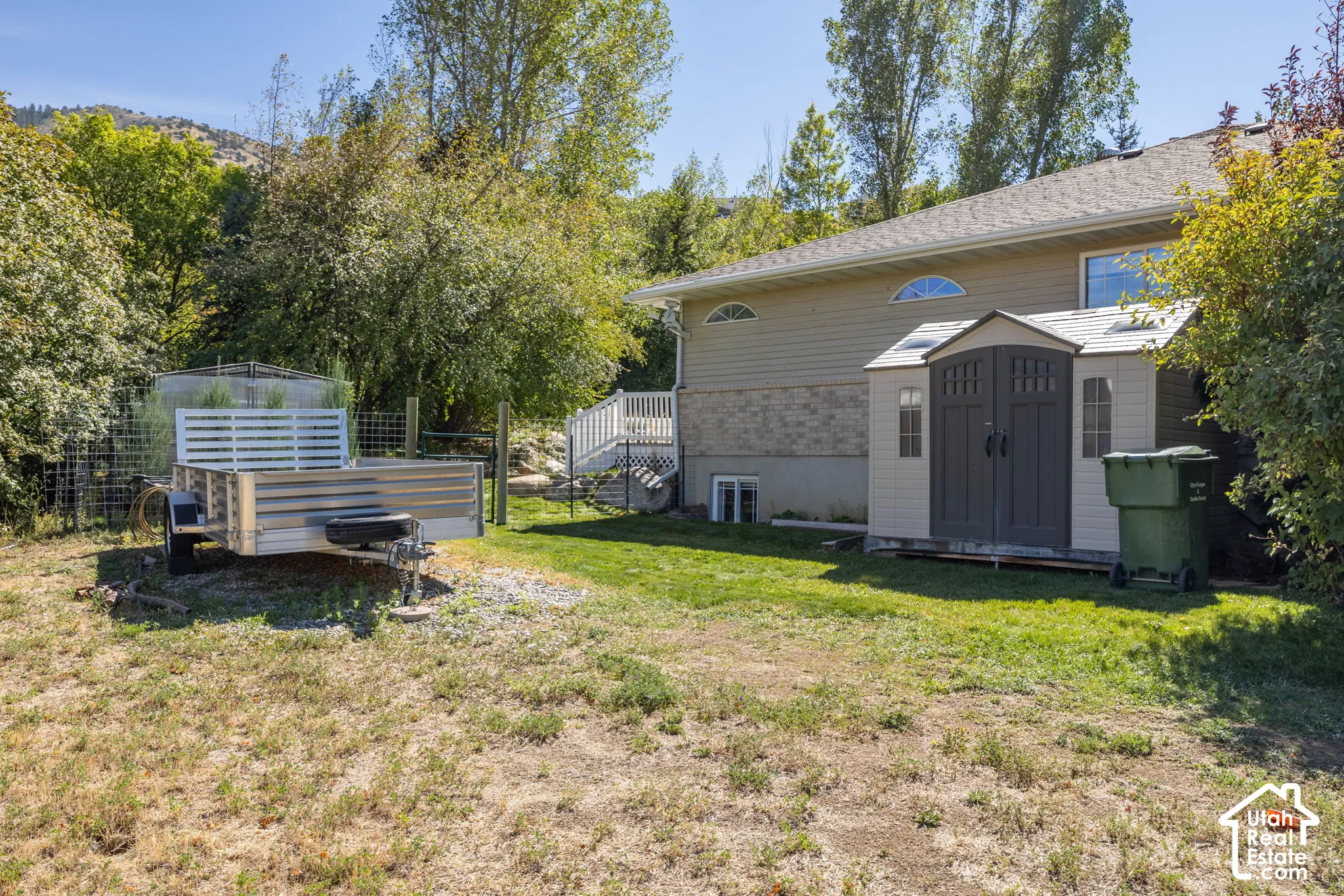 Expansive backyard with a manicured lawn, an outdoor storage shed, and a multi-level deck