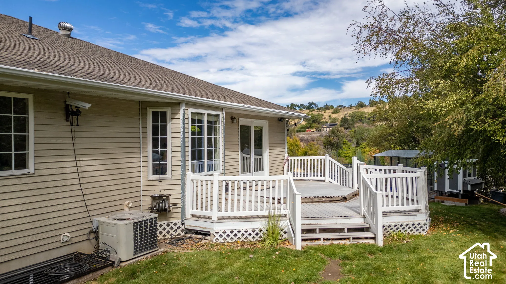 Deck with white railings and lattice skirting, offering direct access to the interior