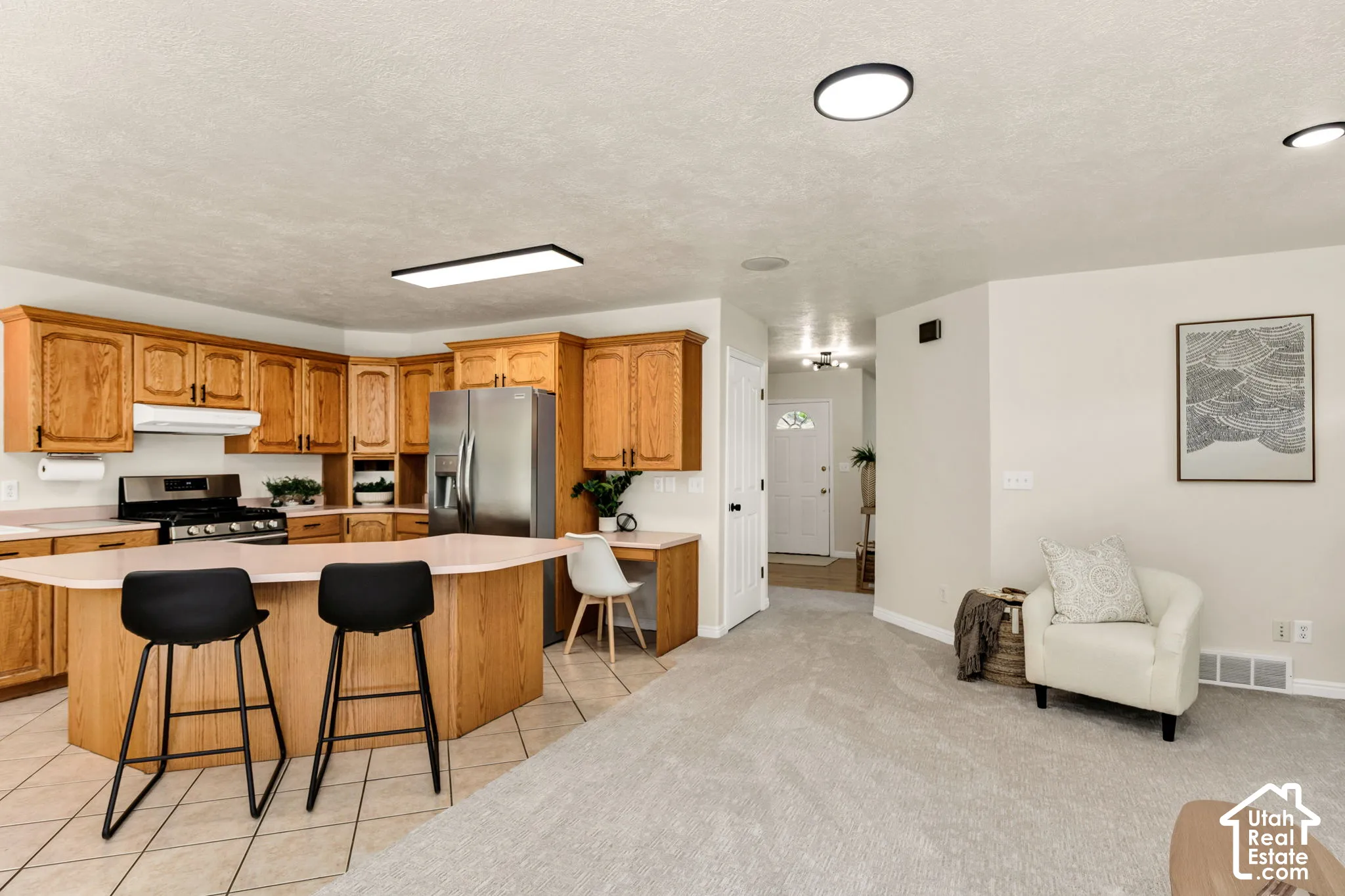 Kitchen featuring wood-finish cabinetry, stainless steel appliances, and a central island with a countertop