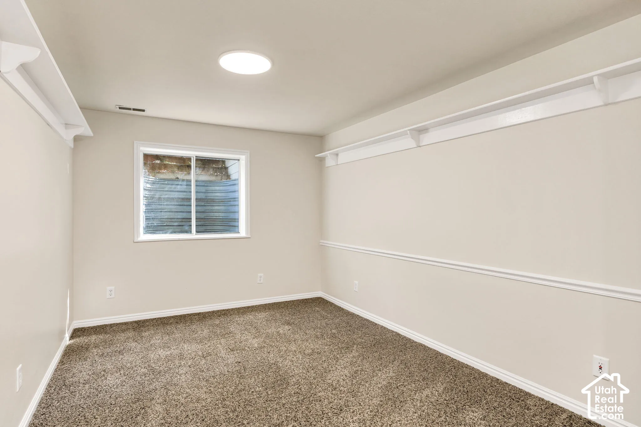 Recessed lighting, window, molding, chair rail, and carpeted flooring