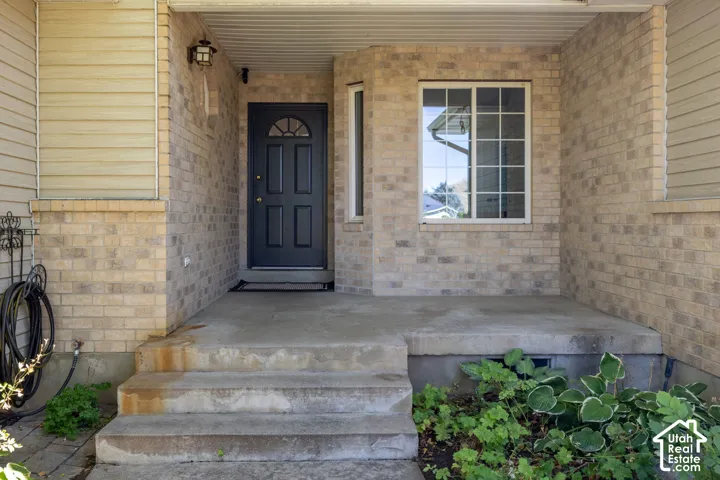 Brick facade with siding accents, covered entry, solid panel door with arched glass, and a multi-pane window