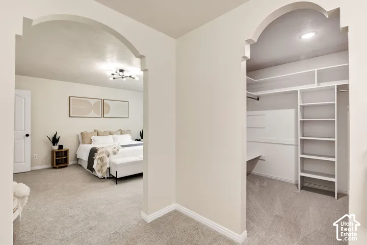 Archway entry to a bedroom with neutral wall tones and a contemporary ceiling light fixture