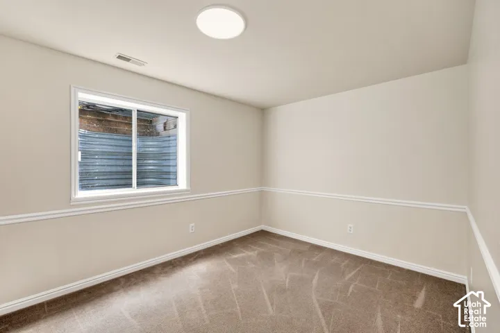 Recessed window with white trim, neutral carpet, and white wall molding