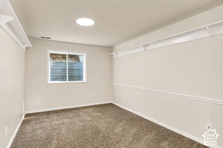 Recessed lighting, window, molding, chair rail, and carpeted flooring