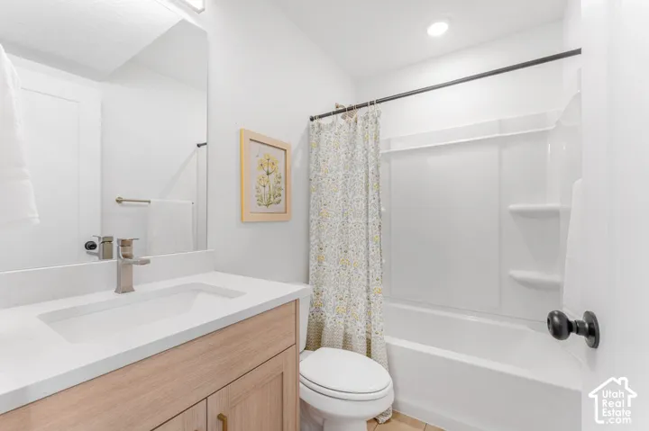 White countertop vanity with a light wood-finish cabinet, brushed nickel faucet, and integrated sink