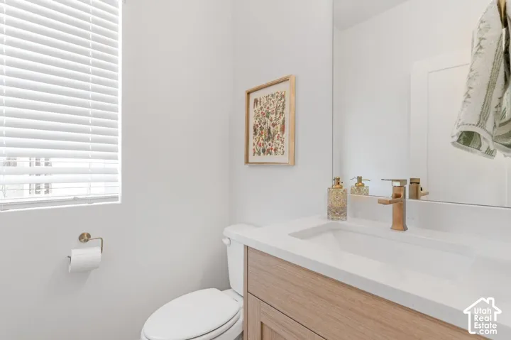 Integrated vanity with an undermount sink, a bronze-finish faucet, and a light wood-finish cabinet