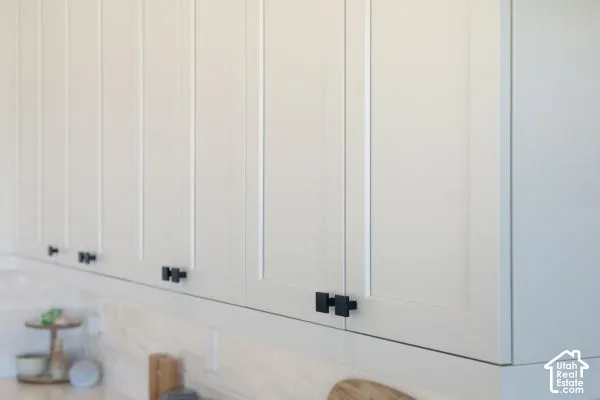 White Shaker-style cabinetry with matte black hardware and a white subway tile backsplash. The photos are renderings only - these photos are for a similar unit in Discovery Ridge. Not this actual model.