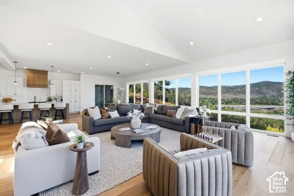 Expansive open-concept living space featuring wood-finish flooring and numerous large windows. The photos are renderings only - these photos are for a similar unit in Discovery Ridge. Not this actual model.