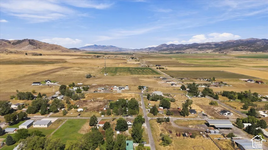 Expansive land featuring agricultural fields, natural terrain, and distant mountains