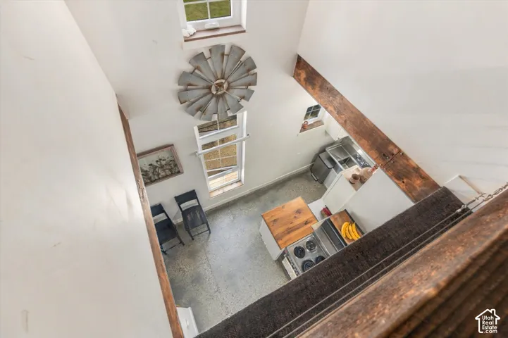 Exposed wood beams, vaulted ceilings, and a spiral staircase with carpeted treads