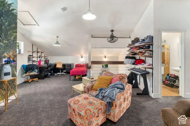 Sloped ceilings, overhead track lighting, wood-finish flooring, and built-in wall shelving