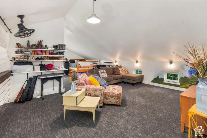 Sloped ceilings with recessed lighting, wall-mounted shelving, and a ceiling-mounted fan