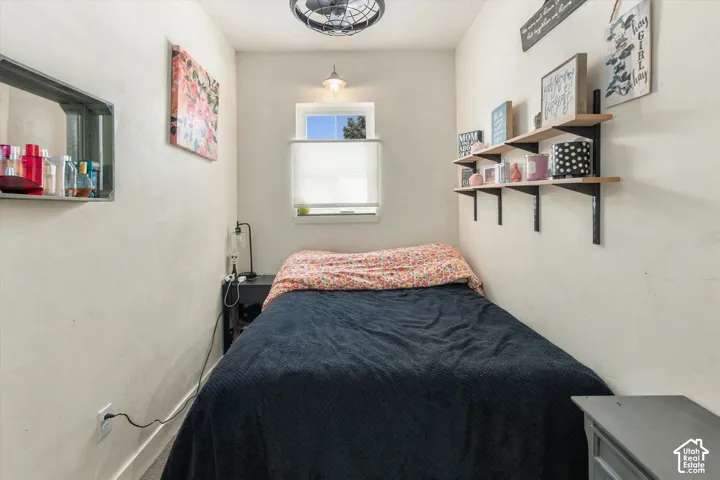 Recessed window with privacy blind, wall-mounted shelving, built-in wall niche, and overhead ceiling fan with lighting