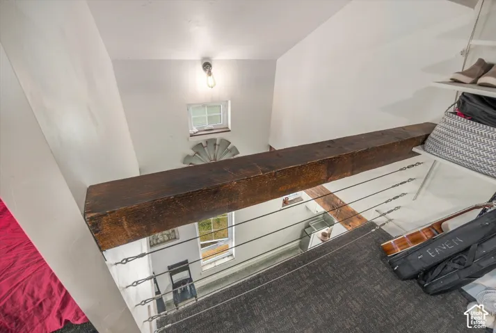 Stairwell featuring a robust wood beam and cable railing system