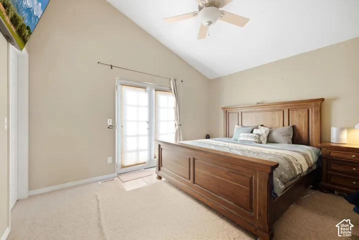 Vaulted ceiling with a ceiling fan, carpeted flooring, and French doors