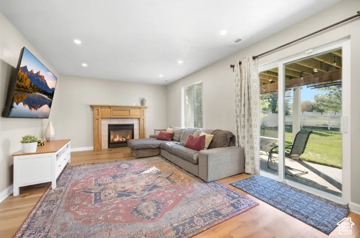 Hardwood-finish flooring, recessed lighting, and a fireplace with a wood mantle
