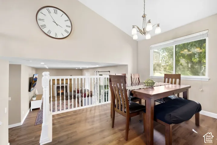 Vaulted ceilings, wood-finish flooring, white railing, and a window for natural light