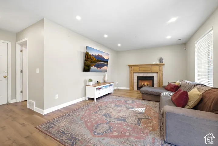 Wood-finish flooring throughout, recessed lighting, and a fireplace with a detailed wood mantel