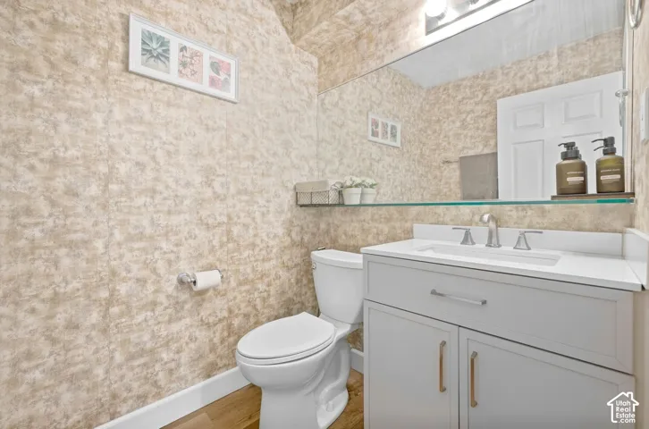 Vanity with an integrated sink, broad wall-mounted mirror, and overhead vanity lighting