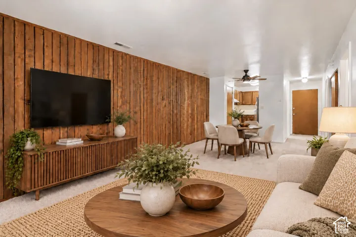 Wood panel accent wall, recessed lighting, carpeted flooring, built-in ceiling fan, interior paneled door