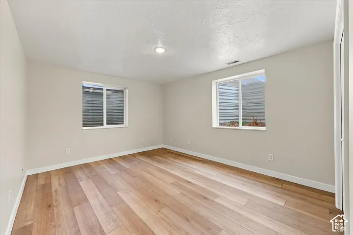 ADU Basement - Recessed lighting, wood-finish flooring, and light neutral wall tones