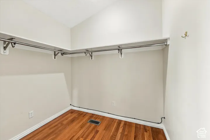 ADU Basement - Hardwood-finish flooring, built-in shelving, and metal hanging rods