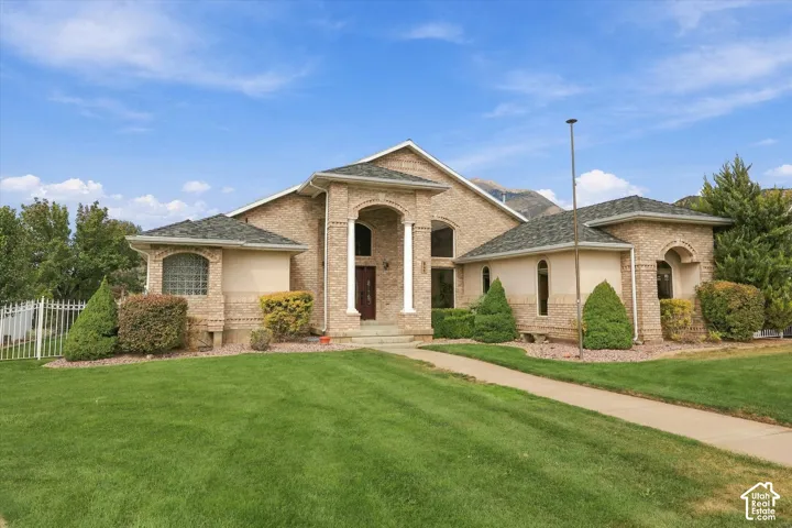 Brick exterior with architectural columns, arched window details, and mature landscaping
