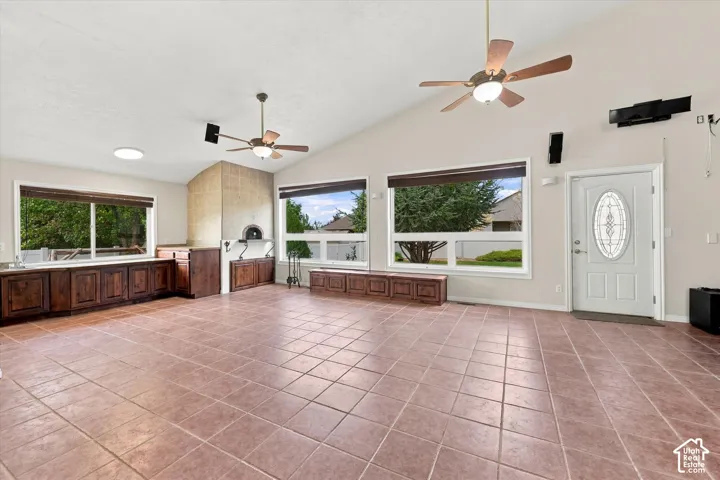 Bonus Room featuring Built In Pizza Oven. Tiled flooring extending throughout, vaulted ceilings with dual ceiling fans, built-in cabinetry with countertops, and a front entry door with an oval glass insert