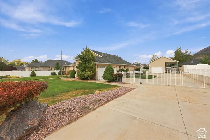 Two-car garage, manicured lawn, established landscaping, privacy fencing, and a detached carport