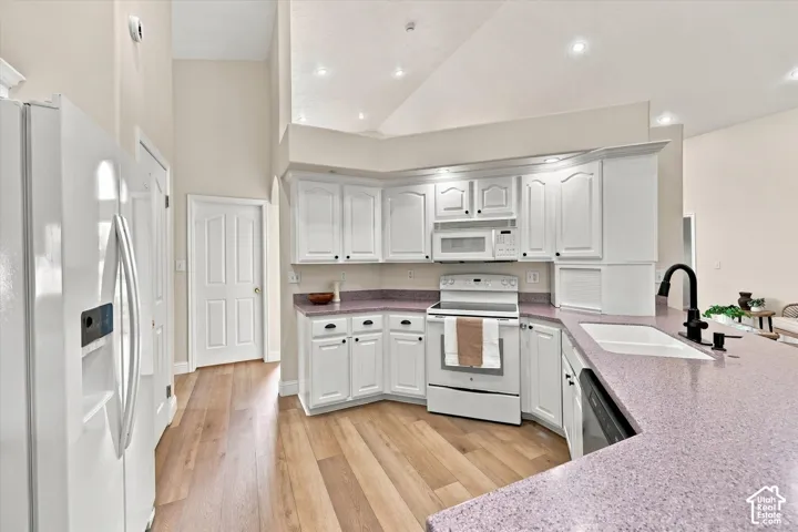 White cabinetry, purple speckled countertops, wood-finish flooring, recessed lighting, and a white sink with a matte black faucet