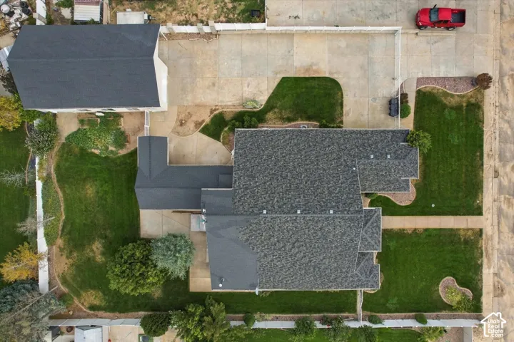 Expansive lot featuring a large main residence, a detached auxiliary building, extensive concrete driveways, and landscaped green spaces