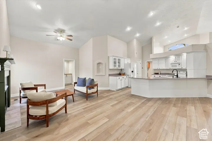 Open-concept living space with vaulted ceilings, wood-finish flooring, and recessed lighting