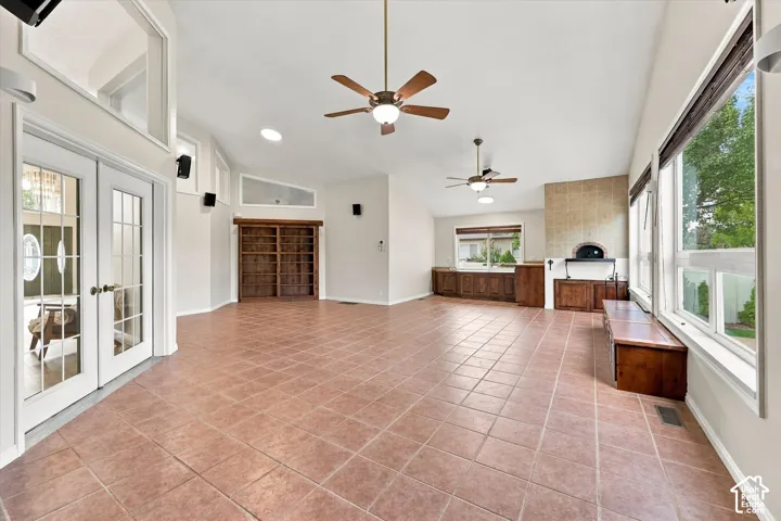 Bonus Room featuring Built In Pizza Oven.Vaulted ceiling with multiple ceiling fans, extensive tile flooring, built-in cabinetry, and large windows