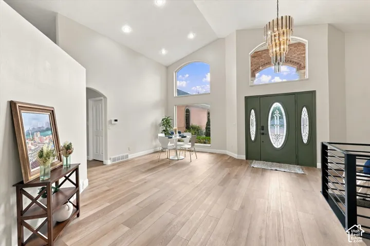 Grand entryway featuring a large arched transom window above a double door with decorative glass inserts