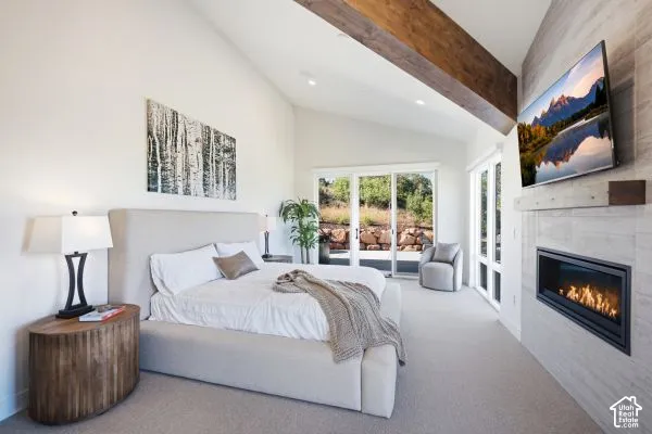 Vaulted ceilings with exposed wood beams, a built-in fireplace with a stone surround, and floor-to-ceiling glass doors