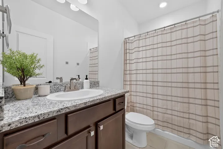 Granite-style countertop with an undermount sink, dark wood-finish cabinetry, and a full-width vanity mirror