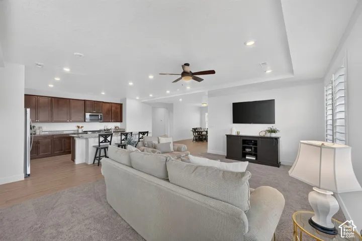 Recessed lighting, ceiling fan, wood-finish flooring, dark wood cabinetry, and stainless-steel appliances