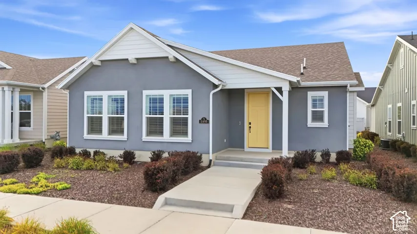 Stucco exterior with contrasting white trim, covered entry, and a bright yellow front door
