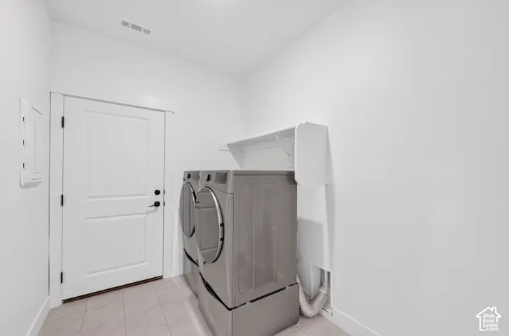 White painted walls, light tile flooring, built-in shelving, panel door